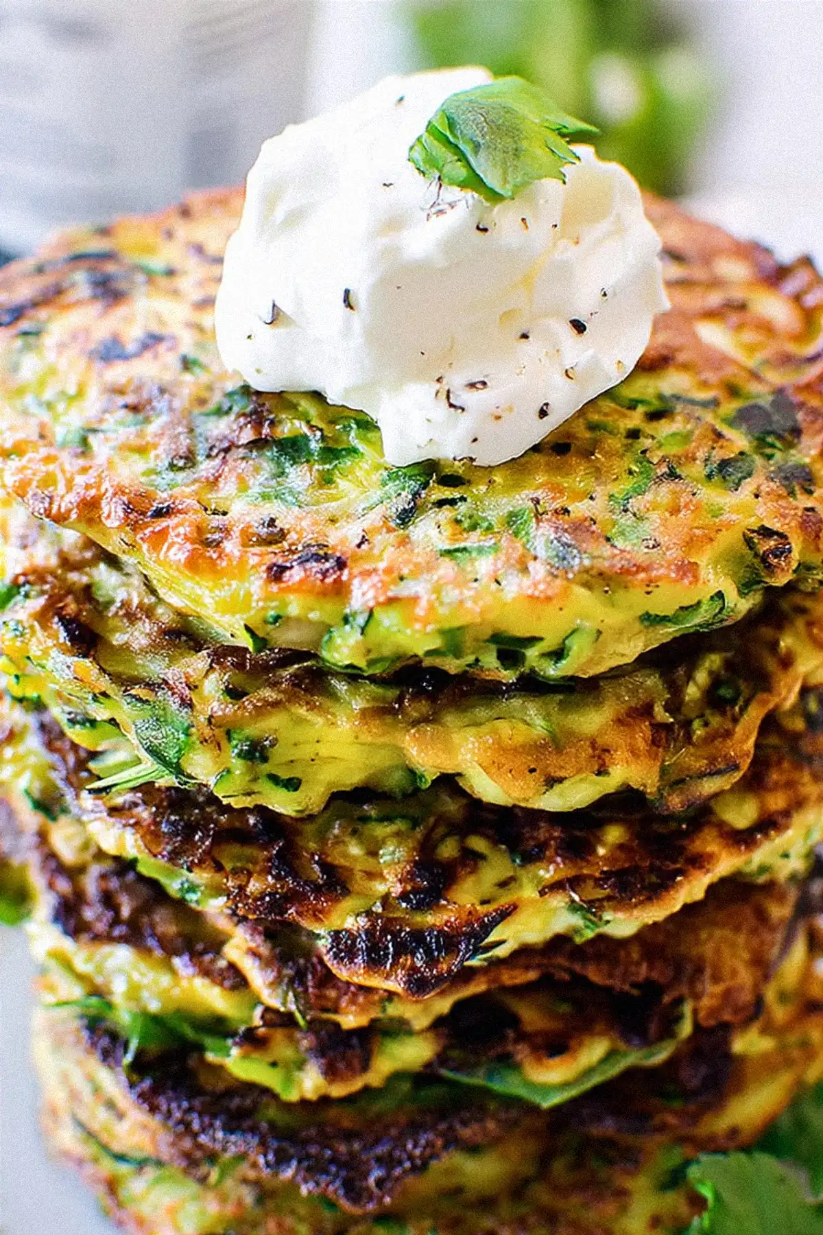 Хрупкави зеленчукови кюфтета, приготвени от настъргани тиквички, лук и ароматни подправки, подредени върху решетка за охлаждане след изпичане. Перфектен избор за здравословно предястие или основно ястие, подходящо за вегетарианци.