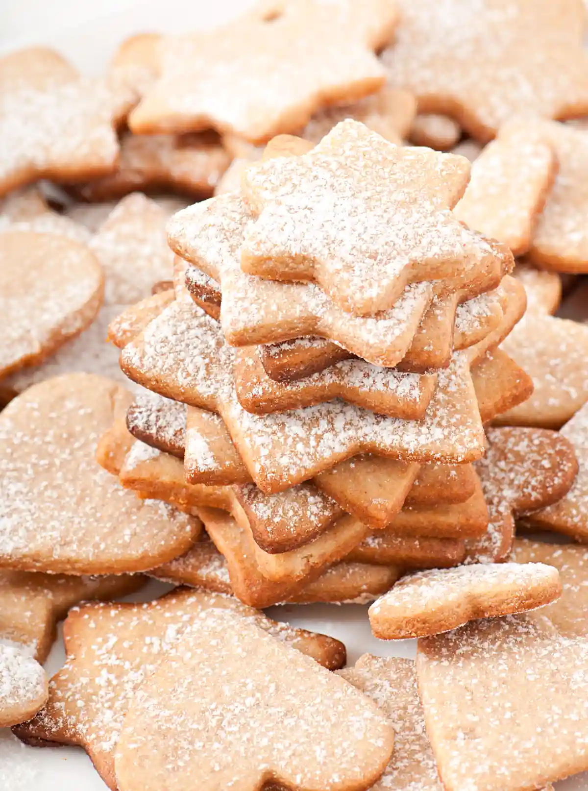 Домашни коледни бисквити във формата на звезди и сърца, поръсени с пудра захар